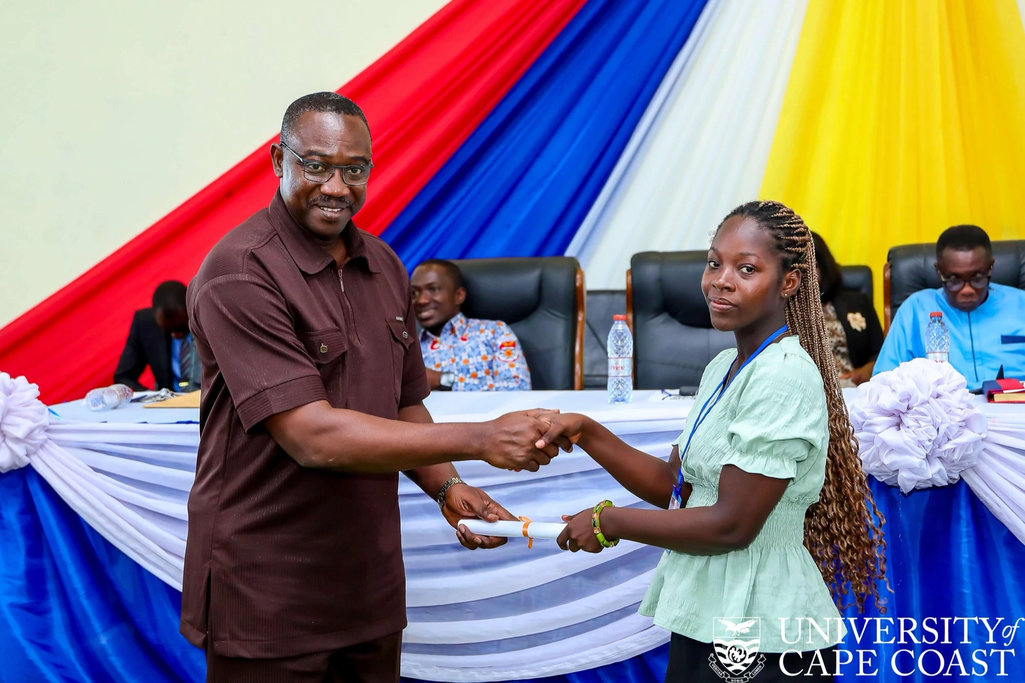A UCC scholarship awardee receives their certificate
